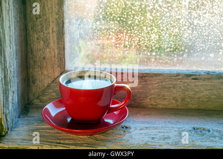 cup of steaming coffee on a window sill Stock Photo