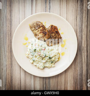 Roasted tenderloin of pork with mayonnaise potato salad on the plate. Food theme. One portion. Lunch menu. Stock Photo