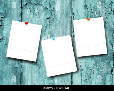 Close-up of three blank instant photo frames with pins on aqua scratched wooden background Stock Photo
