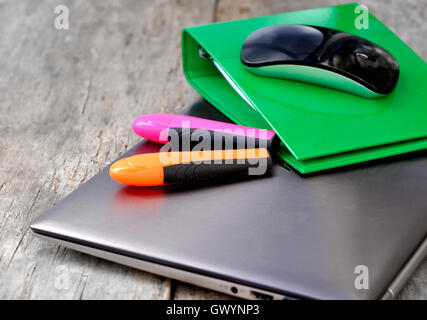 mouse on a binder on a closed laptop in wooden background Stock Photo