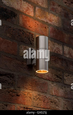 Brushed silver chrome steel metal uplighter downlighter on outside brick wall Stock Photo