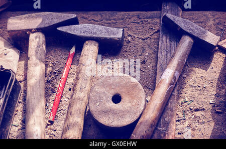 Retro toned old tools on dusty wooden table in a joinery. Stock Photo