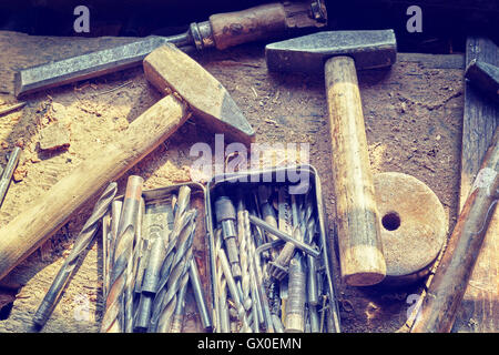 Retro toned old tools on dusty wooden table in a joinery. Stock Photo
