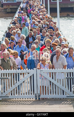 Crowds queue at Yarmouth Pier waiting for the Waverley paddle steamer to arrive for a trip around the Isle of Wight, Hampshire UK in September Stock Photo