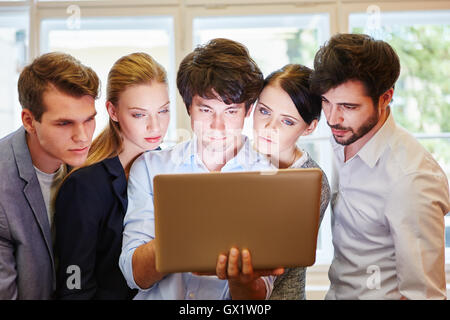 Business team looking at laptop monitor and thinking Stock Photo