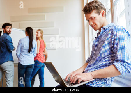 Young businessman working with laptop in his start-up company Stock Photo