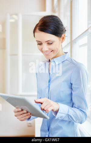Successful Student working on her tablet computer in start-up company Stock Photo