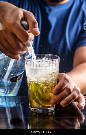 Bartender pours soda water in mojito cocktail Stock Photo