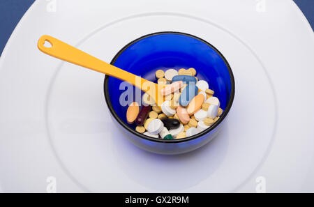 A Bowl full of tablets and capsules placed in plate. Stock Photo