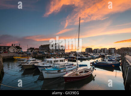 West Bay, Dorset, UK - 14th September 2016. UK Weather.  A glorious sunset illuminating the clouds above West Bay Harbour in Dorset, UK.  West Bay is one of the locations for the hit ITV series Broadchurch.  Picture: Graham Hunt/Alamy Live News