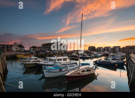 West Bay, Dorset, UK - 14th September 2016. UK Weather.  A glorious sunset illuminating the clouds above West Bay Harbour in Dorset, UK.  West Bay is one of the locations for the hit ITV series Broadchurch.  Picture: Graham Hunt/Alamy Live News