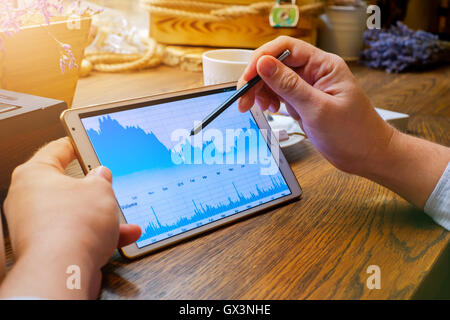 Business man works on tablet pc in cafe Stock Photo