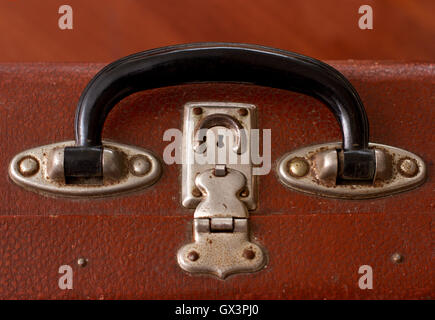 Handle of an Old Vintage Dusty Brown Suitcase on a white background Stock Photo