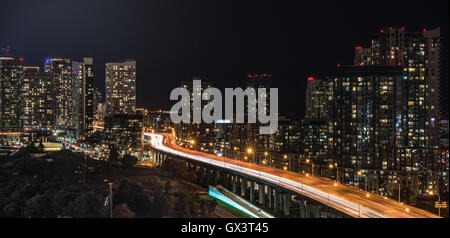 Glowing cityscape and buildings as light streaks along Gardiner Expressway on a hot & muggy summer night in Lakeside Toronto. Stock Photo