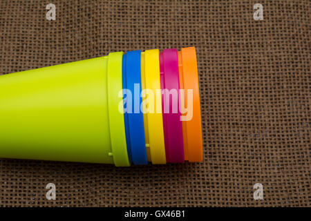plastic multi-colored glasses isolated on dark background. Glass of various color. Stock Photo