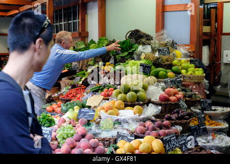 Pakistani shoppers purchase vegetables from a stall inside a