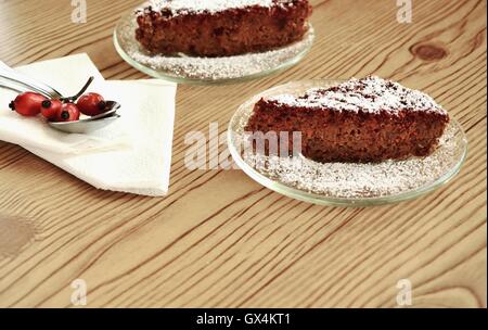 Two slices of chocolate cake and rose hips Stock Photo