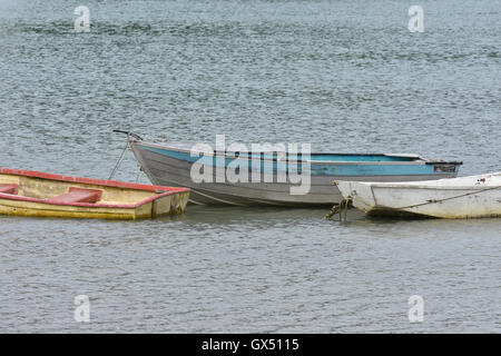 Worn out dinghies on calm water Stock Photo