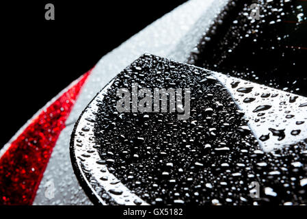 Rain water drops on car body black red Stock Photo