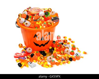 Halloween Jack o Lantern candy pail overflowing with assorted sweets over a white background Stock Photo