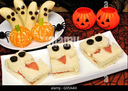 Healthy Halloween treats, monster sandwiches, banana ghosts and orange pumpkins with holiday decor Stock Photo