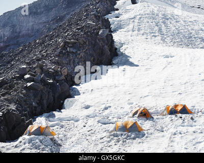 Hikers pitched their tents on a snowy slope on the journey to Mt. Rainier's summit. Stock Photo