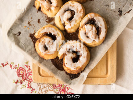 Cinnamon scrolls with icing on baking tray Stock Photo