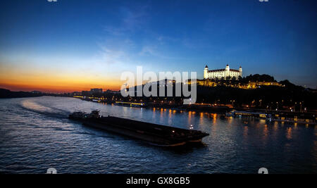 Bratislava Castle Danube Slovakia, Boat on the Danube River in Sunset shipping trade Europe city river Stock Photo