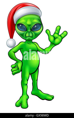 A little Christmas green man alien in a Santa hat cartoon character waving Stock Photo