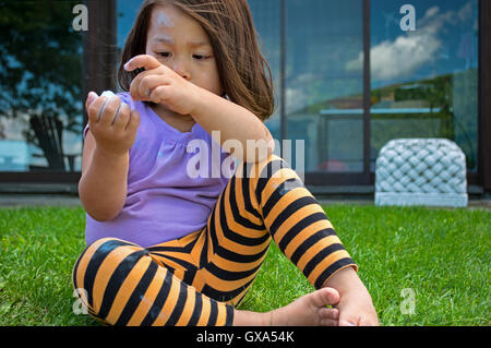 Pre-school child drawing with chalk in the yard Stock Photo