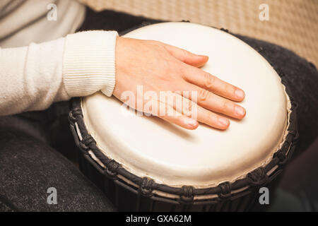 Drummer plays on African drum, closeup photo with selective focus Stock Photo