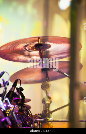 Cymbals in drum set on a stage with colorful illumination, rock music vertical photo background with tonal correction filter Stock Photo