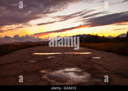 Stratus clouds during a sunset after rain, puddle in old street, Mijas mountains, Andalusia, Spain. Stock Photo