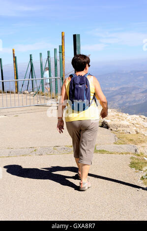 Hiker with backpack reaching the summit of Mont Ventoux to 1912 meters Stock Photo