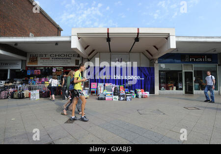 People walk past the closed Harvey retail shopping arcade (centre) in West Gate, Harlow, Essex. Stock Photo