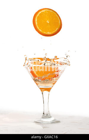 orange slice falling into the cocktail and raises a lot of splashing Stock Photo