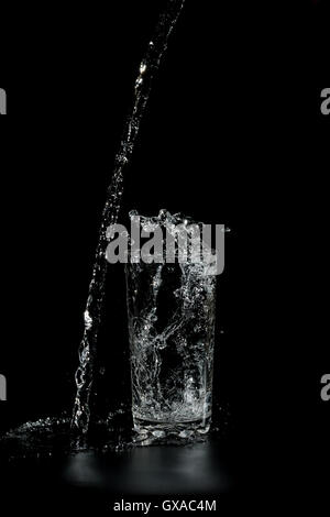 https://l450v.alamy.com/450v/gxac4m/clear-water-pours-into-the-a-glass-beaker-on-a-black-background-gxac4m.jpg