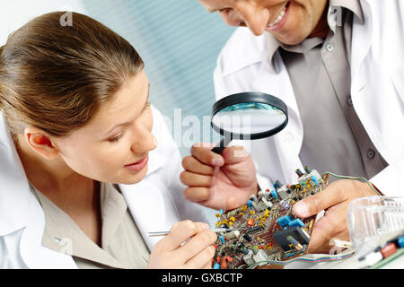 Technicians working on circuit board Stock Photo