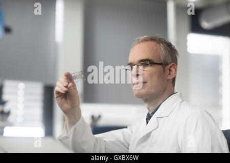 Male meteorologist examining microscope slide in weather station laboratory Stock Photo