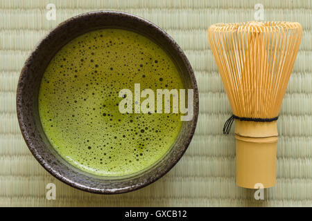 Japanese Matcha green tea in a chawan or traditional ceramic bowl with a chasen or bamboo whisk Stock Photo