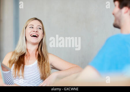 Young male and female students chatting and laughing at higher education college Stock Photo