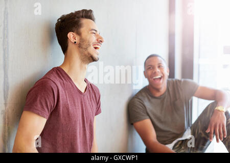 Two young male students in study space laughing at higher education college Stock Photo