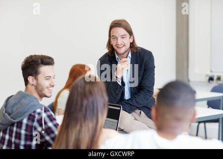 Male lecturer talking to students in higher education college classroom Stock Photo