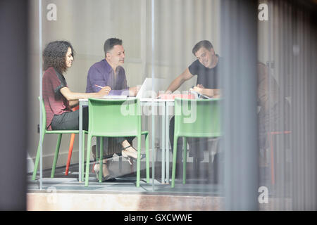 Design team brainstorming at design studio boardroom table Stock Photo