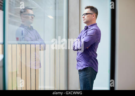 Male designer looking out from window in design studio Stock Photo