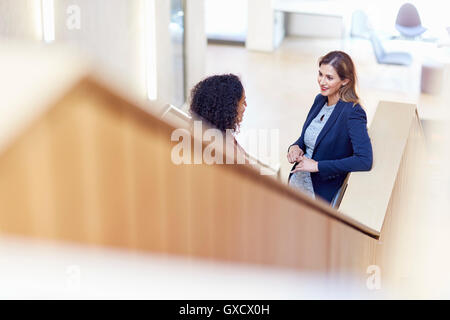 Two businesswomen talking on office stairway Stock Photo