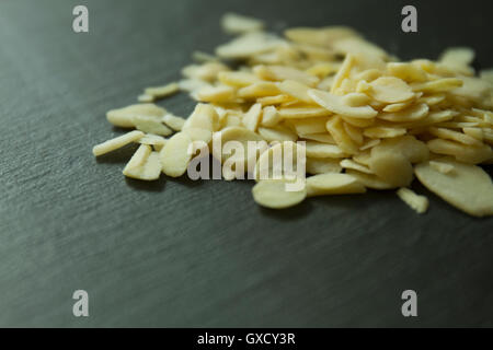 Close up of flaked almonds on wooden surface Stock Photo