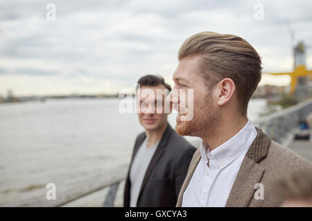 Two businessmen having discussion on waterfront, London, UK Stock Photo