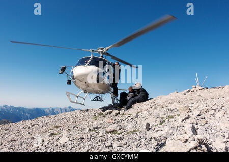 BASE jumping team exiting helicopter on top of mountain, Italian Alps, Alleghe, Belluno, Italy Stock Photo