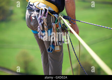 Cropped view of rock climber preparing climbing ropes on safety harness Stock Photo